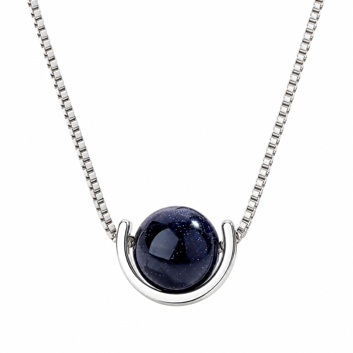 A silver box chain necklace with a modern crescent-shaped silver setting holding a dark blue, starry glass cabochon pendant, shown against a plain white background.