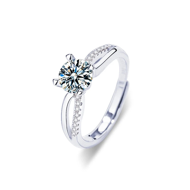 Silver ring with a large diamond and smaller diamonds on the band against a white background