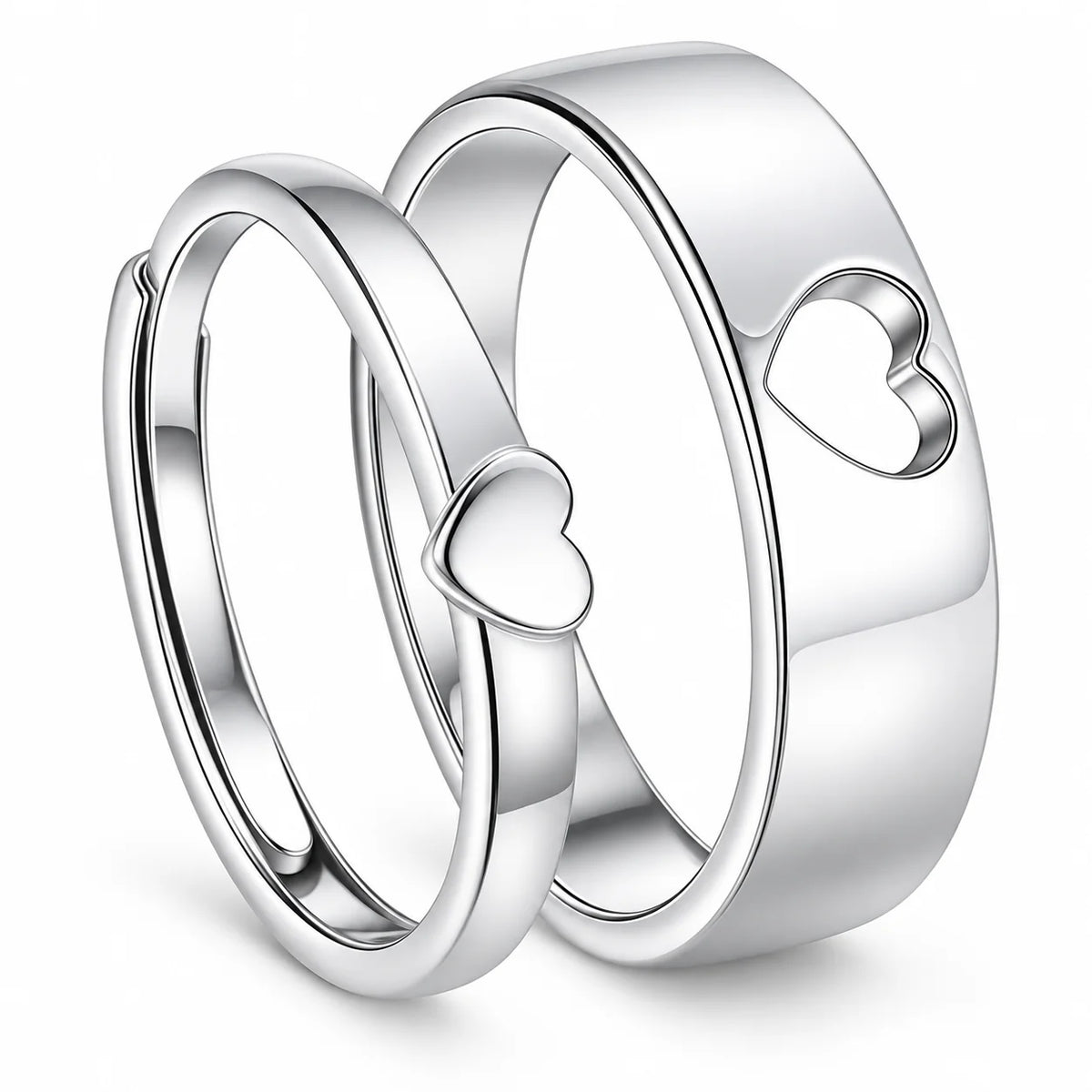 Three polished silver rings with heart motifs, including two overlapping bands with small heart cutouts and one larger band with a larger heart cutout, shown on a white background.