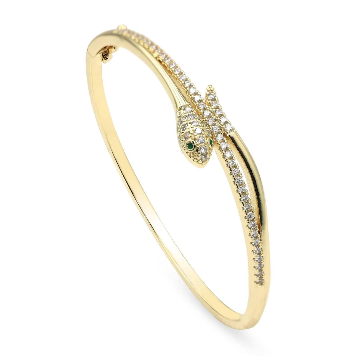 A yellow gold snake bangle bracelet with a head paved with small clear stones and a small green eye, shown on a plain white background.